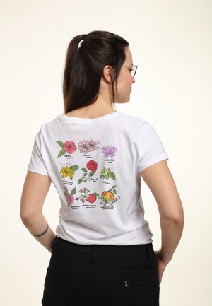 Hvid bomulds T-shirt med et farverigt blomster grafik trykt på ryggen, der viser forskellige blomster forbundet med prinsesser.