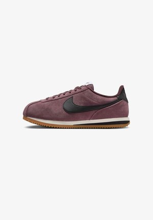 Bordowy zamszowy but sportowy Nike Cortez z czarnym logo Swoosh, białą śródpodeszwą i gumową podeszwą, widok z boku skierowany w lewo.