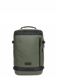 Mochila verde, resistente al agua, con parte superior y acentos en negro. Presenta un bolsillo con cremallera en la parte frontal, hebillas laterales y un asa de transporte.