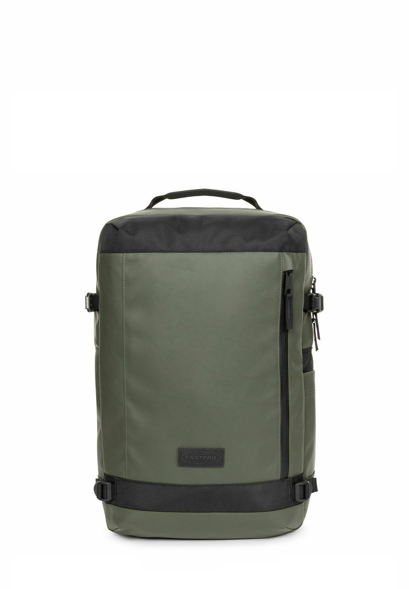 Mochila verde, resistente al agua, con parte superior y acentos en negro. Presenta un bolsillo con cremallera en la parte frontal, hebillas laterales y un asa de transporte.