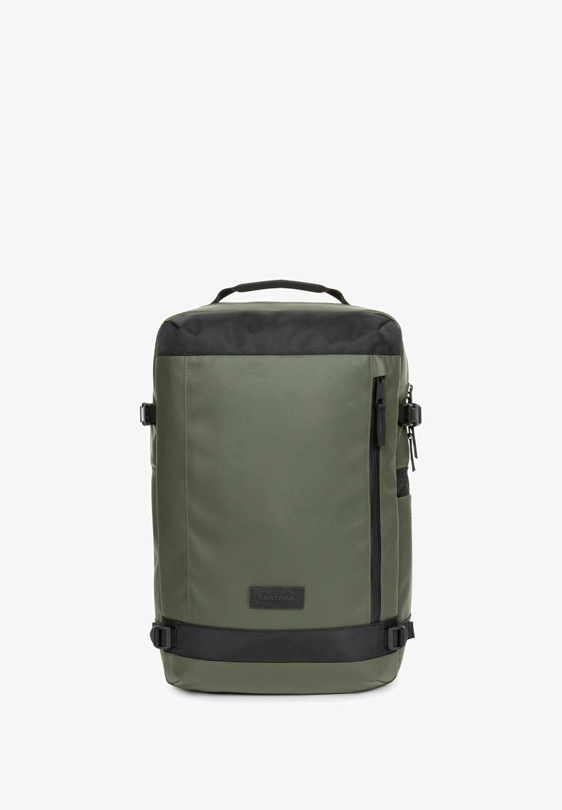 Vihreä, vedenkestävä reppu, jossa musta päällinen ja yksityiskohdat. Varustettu etupuolella vetoketjullisella taskulla, sivusoljilla ja kantokahvalla.