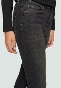 Zwarte denim jeans met een slim fit, voorzien van subtiele wassing, vijf zakken en een standaard knoop- en ritssluiting.