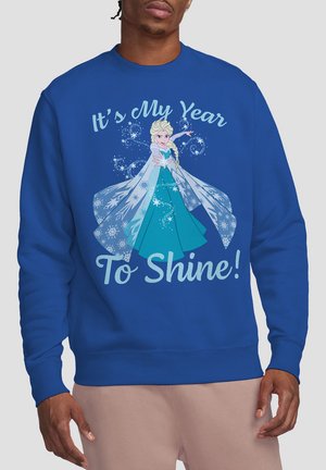 Man wearing blue sweatshirt with animated woman in blue dress casting snowflake magic and text "It's My Year To Shine!"