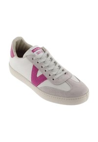 White sneaker featuring a pink suede V logo, grey suede toe cap, and flat white laces. Designed with a cushioned collar and rubber sole.
