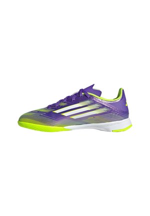 Chaussure de sport basse profil en violet et jaune fluo avec des rayures et des lacets blancs, conçue pour les sports en salle sur fond blanc.