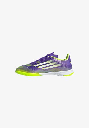 Lila und neon-gelbe, niedrig geschnittene Sportschuhe mit weißen Streifen und Schnürsenkeln, entworfen für Hallensport auf weißem Hintergrund.
