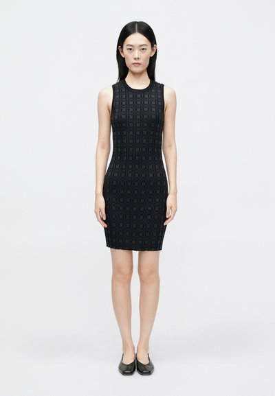 Robe sans manches noire ajustée avec un motif géométrique texturé. Design à longueur de genou avec un décolleté rond et un ourlet uni.