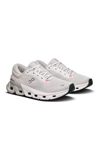 Baskets de sport gris clair avec une tige en mesh respirant, des accents roses et une semelle extérieure rembourrée dotée de découpes distinctes et d'un capuchon noir pour les orteils.