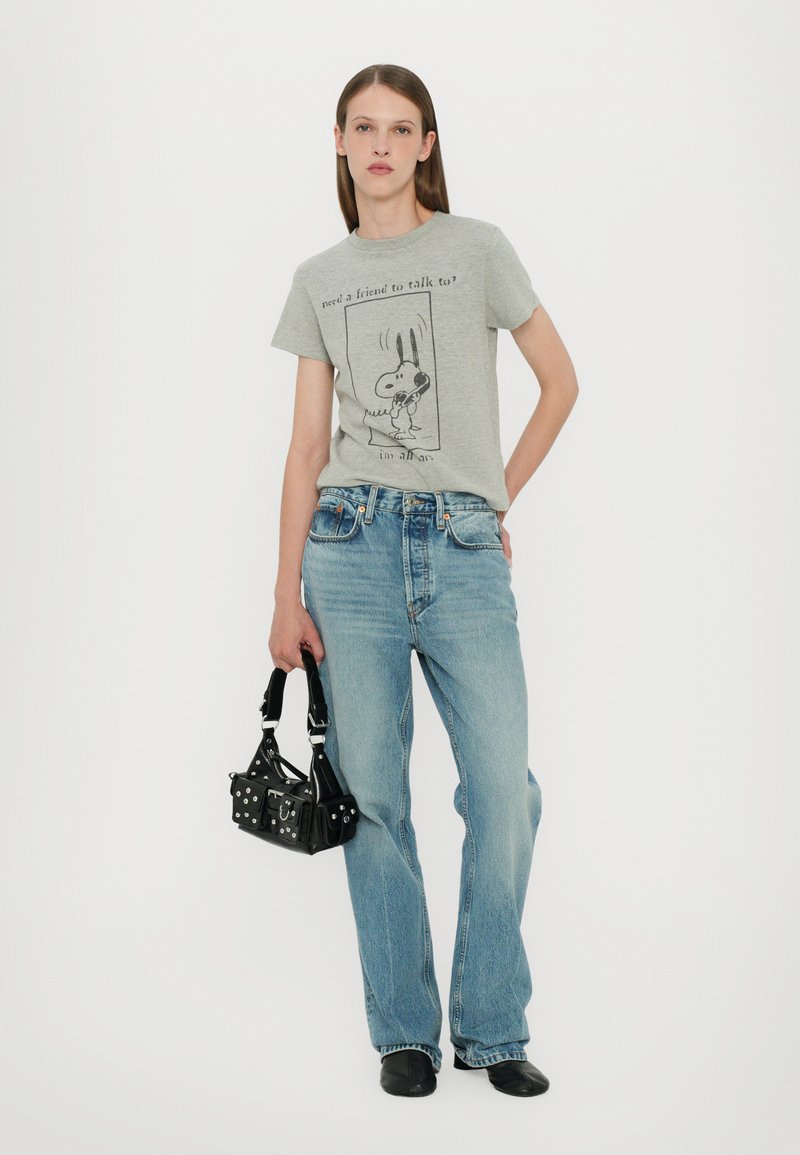 Gray cotton t-shirt with black cartoon print. Light blue denim jeans, black handbag with studs, and black shoes.