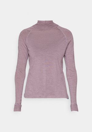 Langærmet top med højt hals i blødt, lys lilla stof. Har raglanærmer og en tætsiddende silhuet med subtil tekstur og syninger.