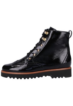 Sort støvle i laklæder med brogue-detaljer, gyldne øjer, sorte snørebånd, brun mellemsål og chunky sort rillesål.