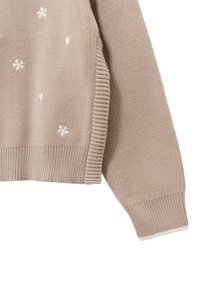 Maglione beige lavorato a maglia con ricami floreali bianchi, polsini e orlo a costine, con una texture liscia e un design a vestibilità rilassata.