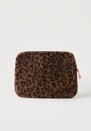 Petite pochette rectangulaire duveteuse imprimé léopard marron et noir avec une fermeture éclair noire et un petit tirette rose sur fond blanc.