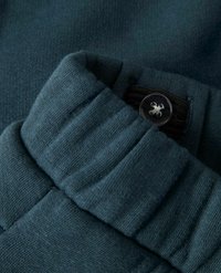 Ciemnozielony elastyczny pasek w talii z regulowanym guzikiem i pętelką z materiału w miękkich dzianinowych spodniach.