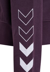Lila Sweatshirt aus einem strukturierten Stoff. Ein weißes Chevron-Muster auf dem Ärmel sorgt für Kontrast. Einfaches, sportliches Design mit einer figurnahen Silhouette.