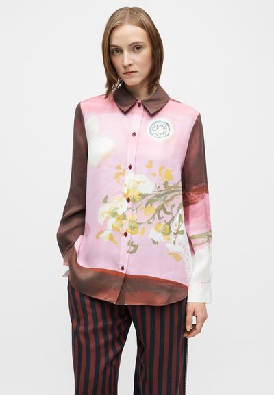 Ilgomis rankovėmis marškiniai su rožinės spalvos gradientu, gėlių raštu ir rudos spalvos apykakle. Priekyje yra sagos ir kontrastingos rankogalių detalės.