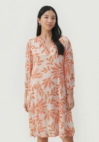 Blommig klänning i ljusrosa med livliga orangea bladmönster. Har V-ringning och trekvartsärmar. Lättviktig tyg med ett flödande design.