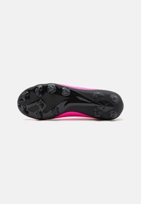Scarpino da calcio rosa con una suola nera texturizzata, dotato di sei tacchetti conici per una buona aderenza e una finitura liscia sul materiale superiore.