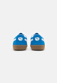 Blaue Wildledersneaker mit weißen Akzenten und einer beige Gummisohle. Verfügt über ein Logo an der Ferse und kontrastierende Textilpanels für das Design.