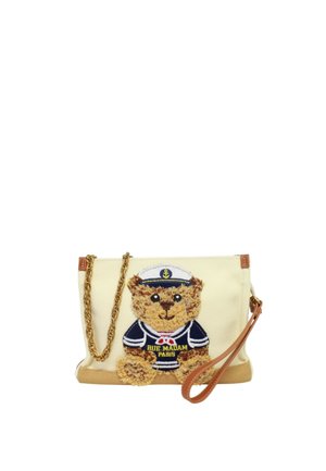 Polsiera in tessuto color crema con un orsetto vestito con un completo da marinaio blu navy e cappello da capitano bianco, dotata di catena dorata e cinturino in pelle.