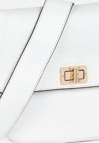 Bolso de piel blanca con un acabado texturizado, que presenta un cierre en tono dorado y una correa a juego. Detalles de costura notables acentúan el diseño.