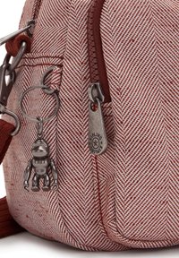 Rød og hvid hvidfiskebensmønstret stoftaske, der har en metalcharmsfigur, lynlås-drag med logo og justerbar rem.