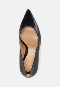 Schwarze Leder-Pumps mit spitzem Zehenbereich, glatter Oberfläche und ausgeschnittenen Seiten. Dekorative Hardware am Absatz und beiges Innenfutter.