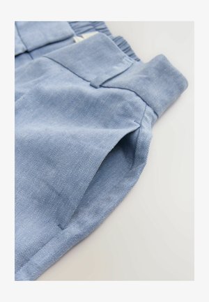Lyseblåt stof med en tekstureret vævning, der har en påsyet lomme og en rynket talje. Materialet ser blødt og let strækbart ud.