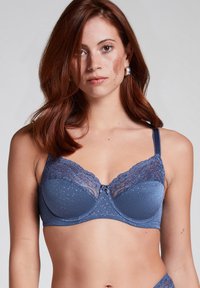 Donderblauwe beha met beugels, versierd met kant aan de bovenrand, met een stippenstructuur op de cups en een klein strikje in het midden.