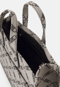 Sac en tissu texturé avec motif noir et blanc, poignées doubles, ouverture en haut et poche intérieure zippée.