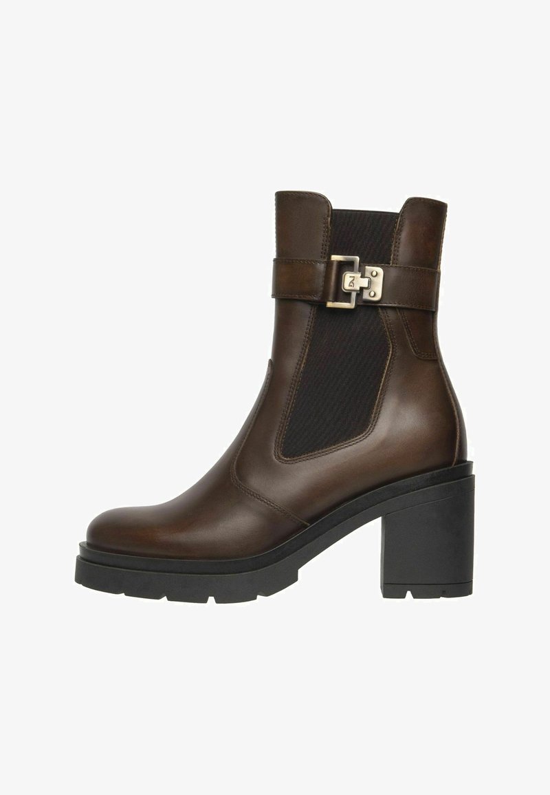 Botte en cuir marron avec panneau élastique noir sur les côtés, sangle à boucle argentée, talon carré noir épais et semelle texturée.
