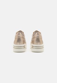 Sneaker in pelle metallica con suola bianca e accenti dorati, caratterizzati da una punta tonda, colletto imbottito e un design minimalista.