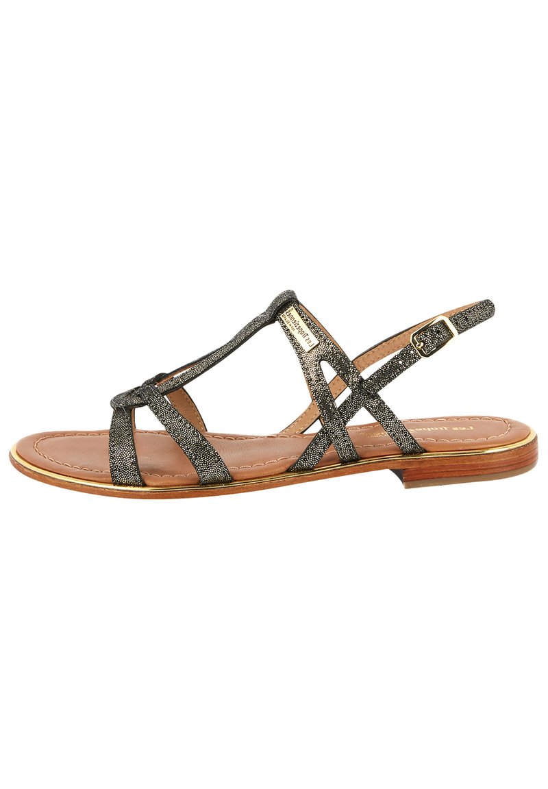 Metalen bronzen platte sandalen met een crisscross ontwerp, voorzien van smalle banden en een gesp-sluiting, op een lichtbruine zool.