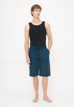 Débardeur noir et short à carreaux vert-bleu avec taille élastique et cordon de serrage. Le short est de longueur genou avec une coupe décontractée.