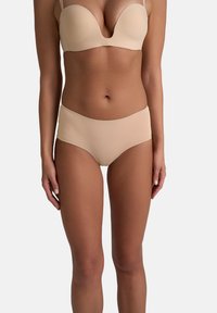 Nude voorgevormde bh met gladde cups en verstelbare bandjes, gecombineerd met nude hooggeprofileerde briefs, naadloos ontwerp, zachte stof.
