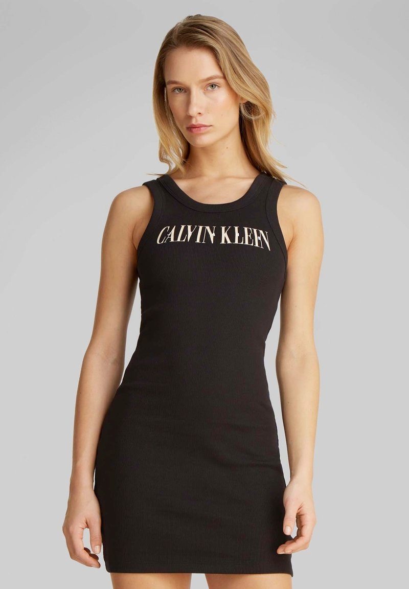 Schwarzes, geripptes Kleid mit rundem Ausschnitt und ärmellosem Design. Auf der Vorderseite prangt "CALVIN KLEIN" in kontrastierender heller Schrift.