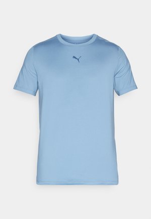 Šviesiai mėlyna trumpomis rankovėmis marškinėliai, pagaminti iš glotnaus audinio. Turi apvalų kaklą ir mažą tamsiai mėlyną Puma logotipą ant krūtinės.