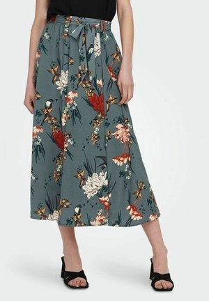 Blumiger Midirock in Petrol, mit einem Bindegürtel, lebhaften roten, weißen und gelben Blumen sowie einer fließenden Silhouette mit weicher Textur.
