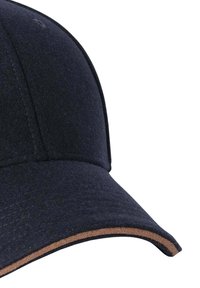 Gorra de béisbol de fieltro azul marino con una superficie texturizada, que presenta un acento marrón en la visera y costuras visibles a lo largo de las costuras.