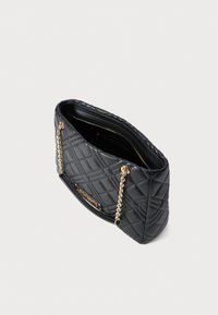 Schwarze, gesteppten Handtasche mit goldenen Kettenriemen, rechteckiger Form, mit Reißverschluss-Innenfach, und strukturierter Oberfläche mit einem Rautenmuster.