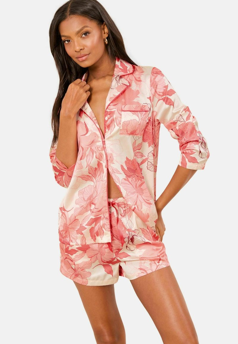 Set de pijama din satin în roz și crem, cu modele florale. Include o cămașă cu nasturi și buzunar, alături de pantaloni scurți asortați cu șnur.
