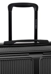 Valise noire avec une surface texturée, fermeture zippée et une poignée télescopique. Logo "WITTCHEN" embossé sur la poignée.