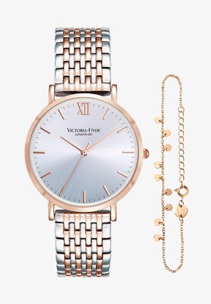 Kello, jossa on hopea ja ruusukultainen väri, metallinen linkkihihna, pyöreä kellotaulu, roomalainen numero XII ja harjattu hopeinen kellotaulu; mukana on herkkä kultaketjukaulaketju.