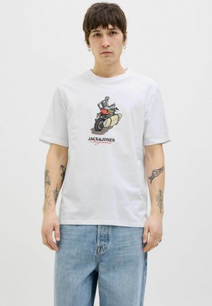 White cotton t-shirt featuring a front graphic of a skeleton on a motorcycle. It has a crew neckline and relaxed fit, worn with light blue jeans.