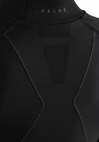 Chemise technique noire avec un col haut, présentant des panneaux texturés et des coutures renforcées. Inclut un logo subtil au niveau du col.