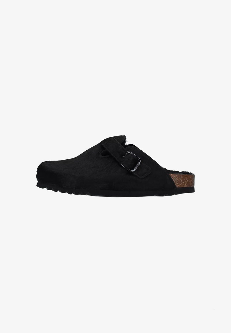 Zoccoli neri pelosi con una soletta in sughero, dotati di una fibbia regolabile e una superficie texturizzata. Design a profilo basso con punta arrotondata.