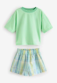 Grünes kurzärmeliges T-Shirt kombiniert mit hellblauen und gelben karierter Shorts. Das T-Shirt hat einen runden Halsausschnitt; die Shorts haben einen elastischen Bund.