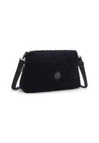 Black, plush-textured bag with a rectangular shape. Features a detachable strap and a round logo patch on the front. Zipper closure.