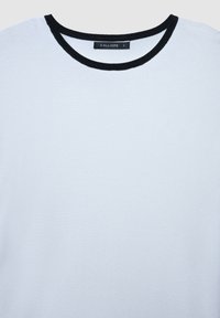 Helles blaues T-Shirt aus weichem Stoff, mit einem schwarzen gerippten Halsausschnitt und einem Etikett mit der Aufschrift "CALLIOPE" in Größe "S". Einfaches Design.