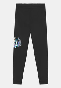 Black fleece joggers featuring a holographic logo design on the left side, with elastic waistband and tapered cuffs.